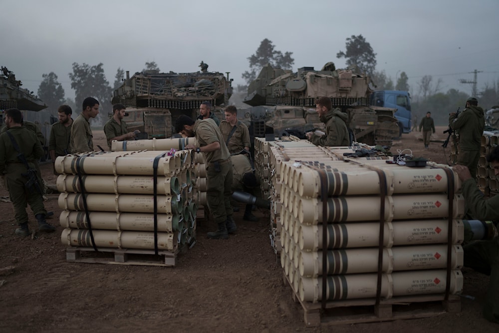 Israeli soldiers from the artillery unit store tank shells in a staging area in the Gaza envelope in southern occupied Palestine, January 1, 2024 (AP)