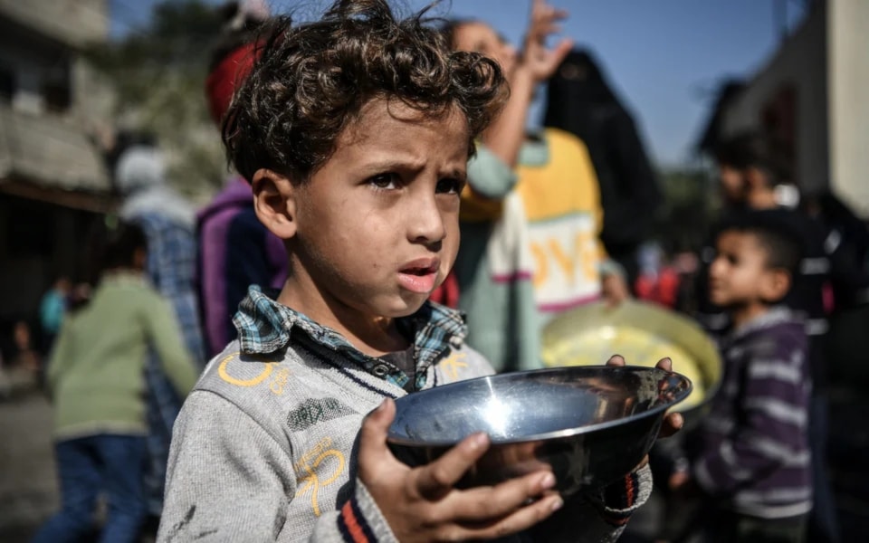 Ahmad, 5-years-old, waits his turn in the crowd to get a meal from a charitable hospice that distributes free food in the city of Rafah, southern the Gaza Strip amid the ongoing Israeli genocide. (UNICEF)