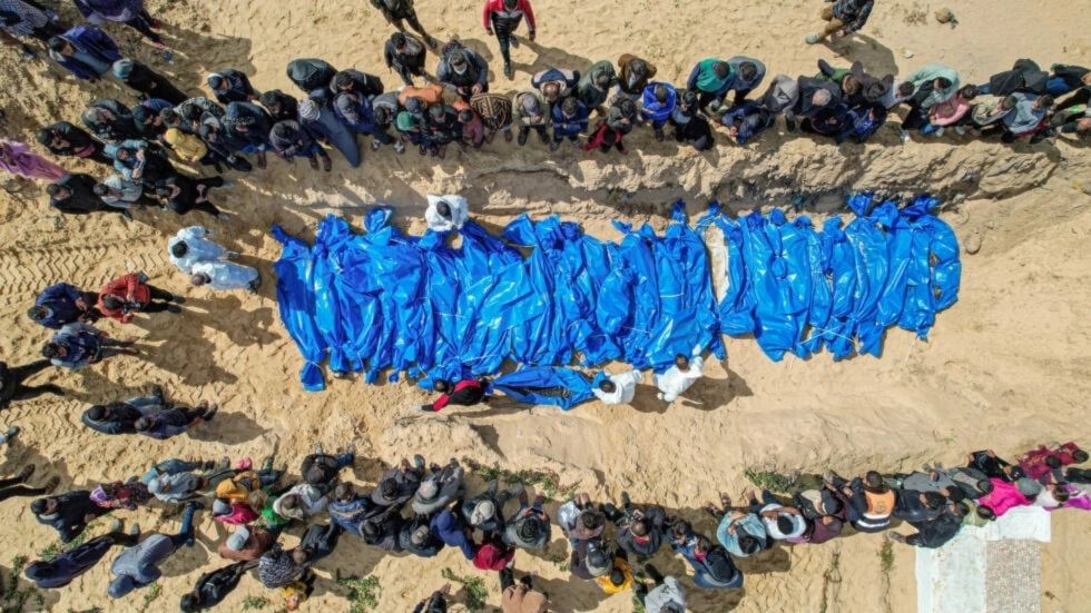 An aerial view of mourners looking on as medics prepare the 47 bodies for mass reburial amid the ongoing Israeli genocide and starvation war in Gaza ( SAID KHATIB / AFP)