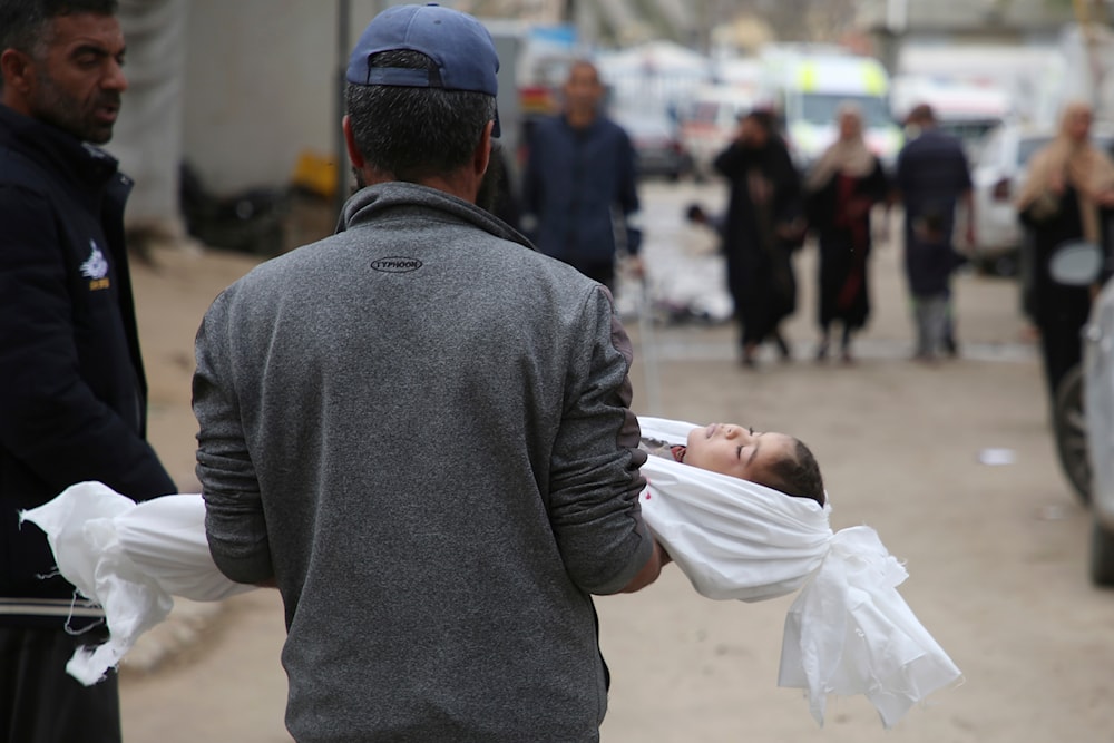 Mohsen Muammar carries the body of his son Muhammad, 3, killed in the Israeli bombardment of the Gaza Strip, on his way to bury him in Rafah, southern Gaza Strip, Friday, March 29, 2024.(AP)