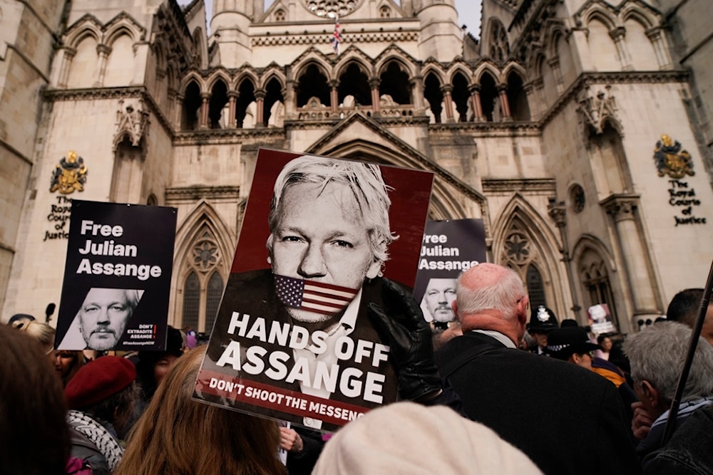 Demonstrators hold placards after Stella Assange, wife of Wikileaks founder Julian Assange, released a statement outside the Royal Courts of Justice, in London, Tuesday, March 26, 2024. (AP)