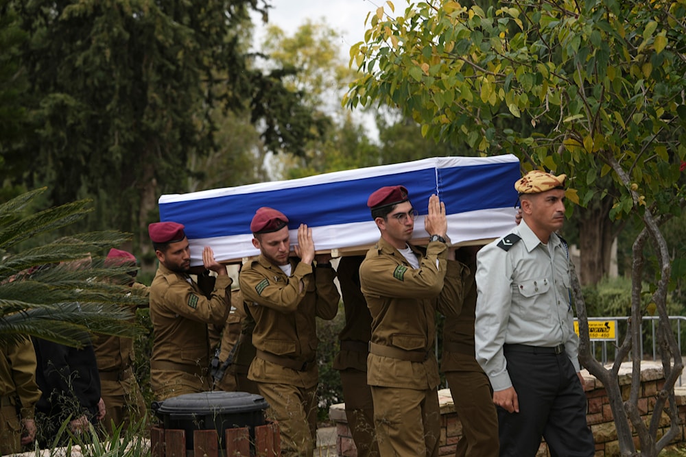 Pallbearers carry the coffin of Israeli occupation forces Sgt. Rotem Sahar Hadar, a Paratrooper killed in the Gaza Strip during his funeral at the military cemetery in Khdeira, occupied Palestine, February 16, 2024 (AP)