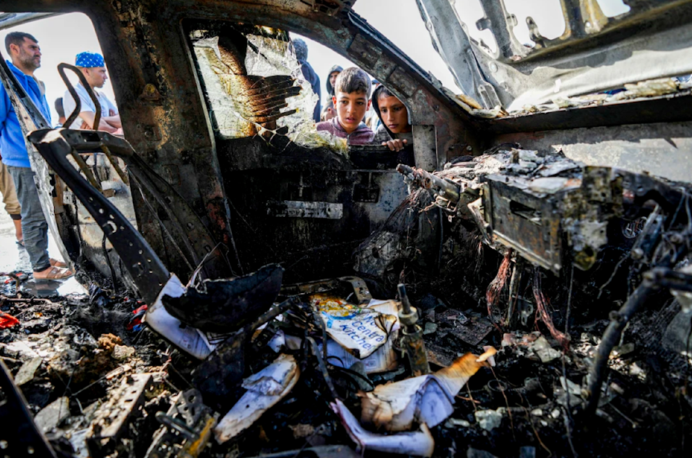 Palestinians inspect the damage from a vehicle after Israeli strikes in Deir al-Balah on April 7, 2024. (AP)