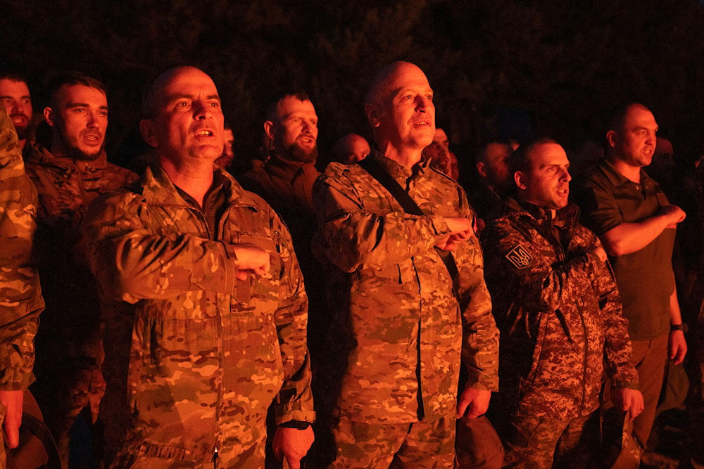 Soldiers of Ukraine's National Guard 3rd Svoboda (Liberty) battalion, Rubezh (Frontier) brigade pray as they stand around a fire during rotation in Ukraine, Thursday, April 11, 2024. (AP)