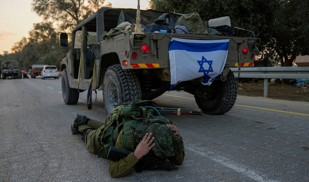 An Israeli occupation soldier mistakenly thinks he hears an air raid siren and jumps to the ground to take cover in kibbutz 'Be'eri', 'Israel', Wednesday, Oct. 11, 2023. (AP)