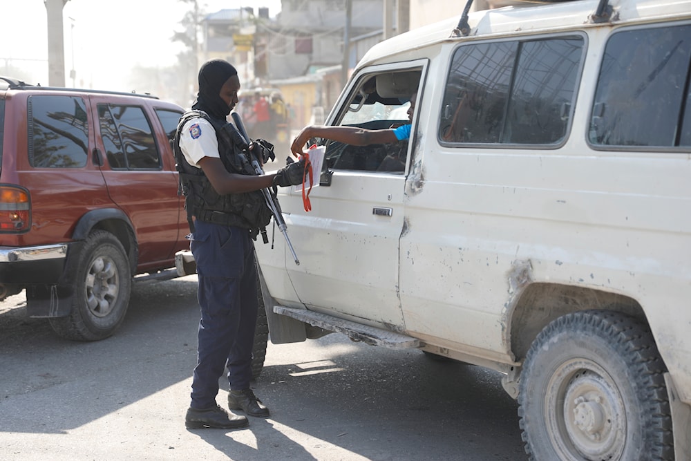 A police officer checks a driver documents at an intersection in Port-au-Prince, Haiti, Saturday, April 6, 2024. (AP)