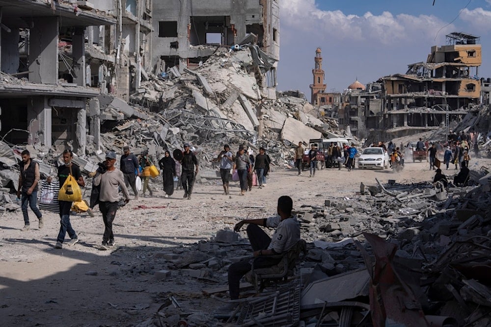 Palestinians walk through the destruction in the wake of an Israeli air and ground attack in Khan Younis, southern Gaza Strip, Monday, April 8, 2024 (AP Photo/Fatima Shbair)