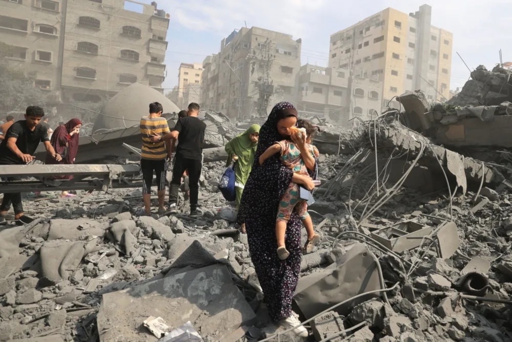Palestinian mother and her child evacuate following an Israeli airstrike on the Sousi Mosque in Gaza on Oct. 9. (AFP  via Getty Images)