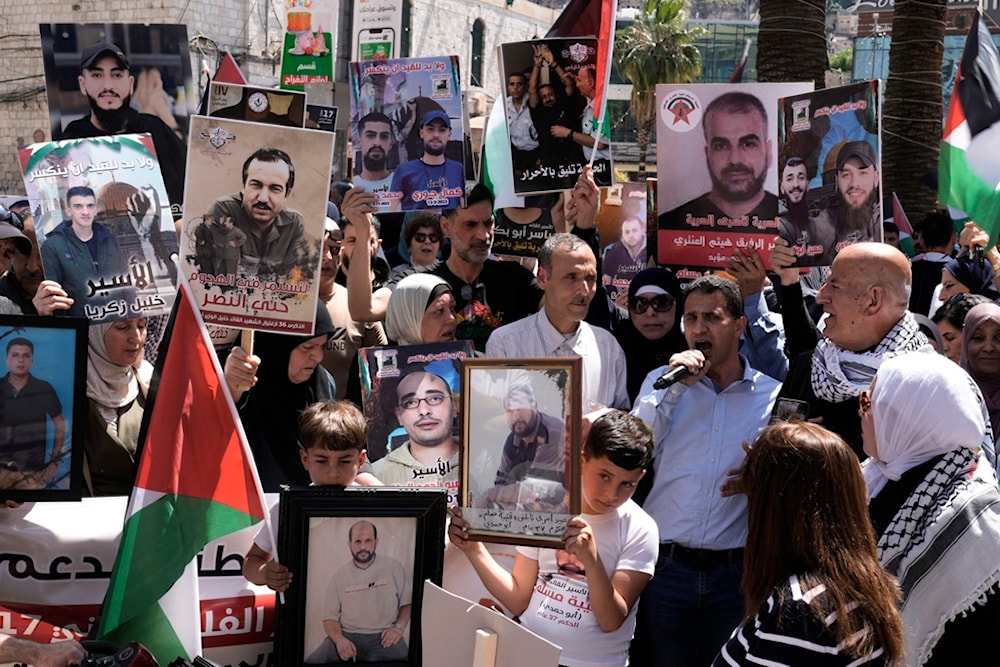 Palestinians hold photographs of prisoners jailed in Israel during a rally marking the annual prisoners' day in the West Bank city of Nablus, Wednesday, April 17, 2024. (AP)