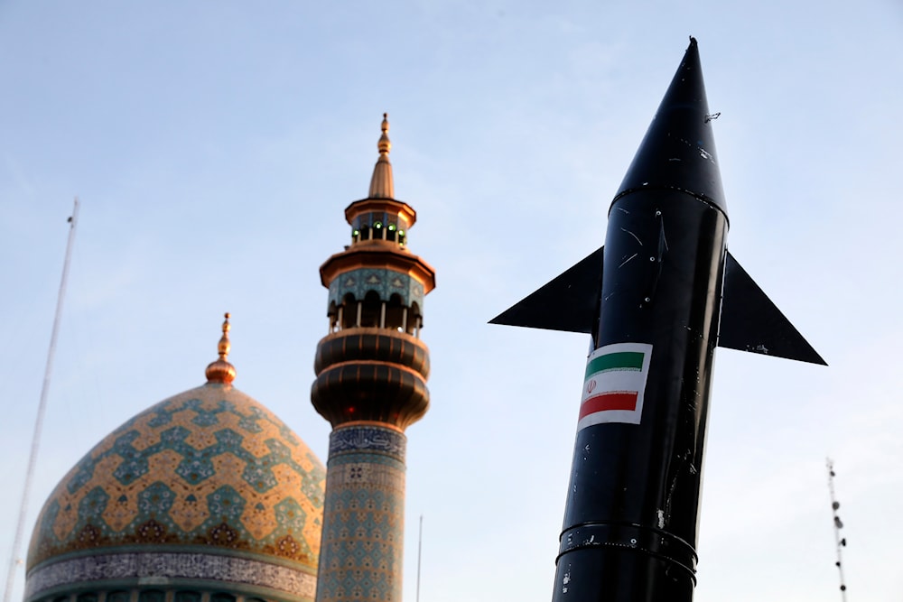A model of a missile is carried by Iranian demonstrators as a minaret and dome of a mosque is seen at background during an anti-Israeli gathering at the Felestin (Palestine) Sq. in Tehran, Iran, Monday, April 15, 2024. (AP)