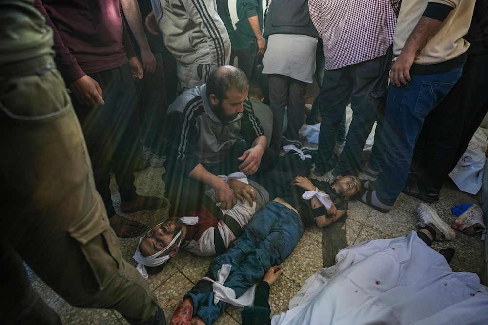 Palestinians mourn next to dead ones in the Al Aqsa hospital in Deir al Balah following an Israeli bombardment in the Maghazi refugee camp, central Gaza Strip, Tuesday, April 16, 2024. (AP)