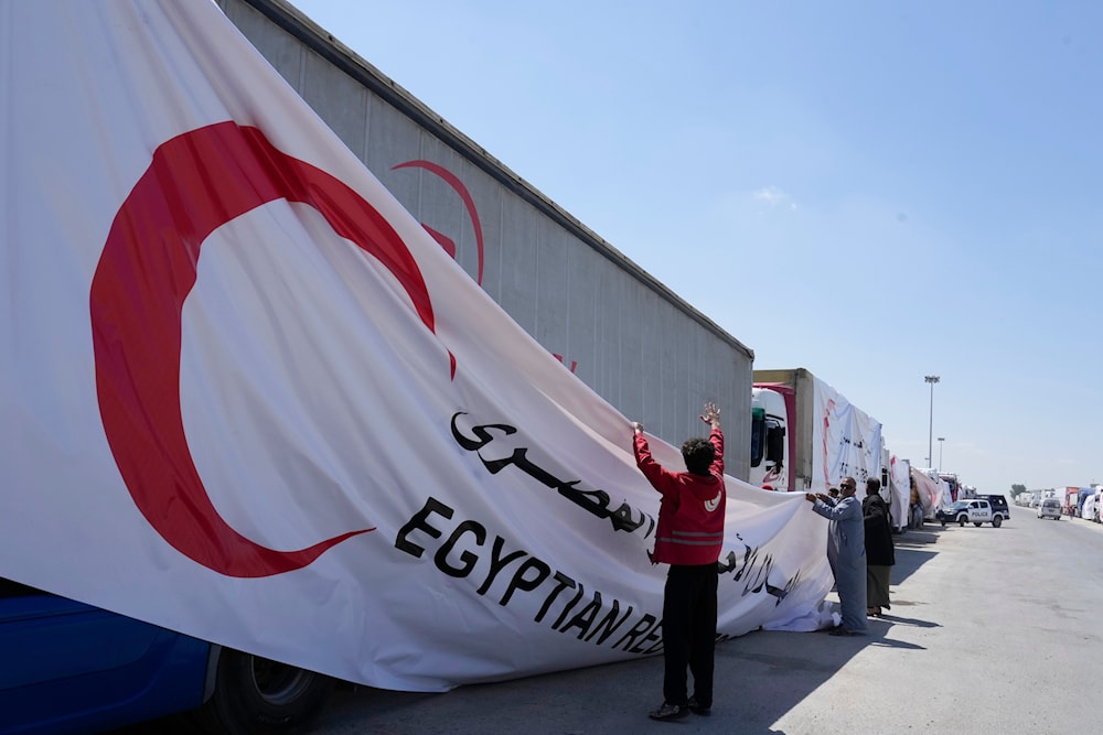 Egyptian drivers cover their trucks of humanitarian aid as they wait to cross the Rafah border crossing between Egypt and the Gaza Strip on Saturday, March 23, 2024. (AP)