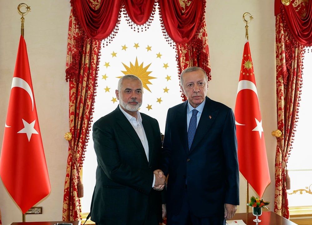 In this photo released by the Turkish Presidency, Turkey's President Recep Tayyip Erdogan, right, and Hamas politburo leader Ismail Haniyeh, shake hands during their meeting in Istanbul, Turkey, April 20, 2024 (AP)