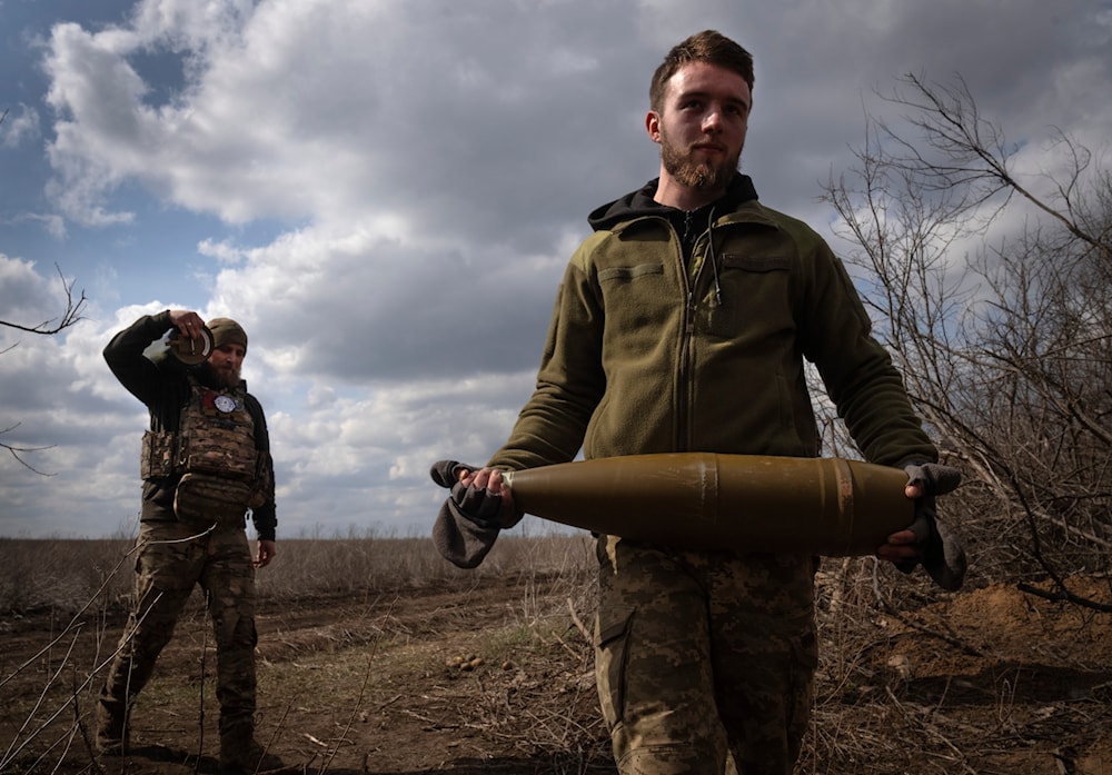 Ukrainian soldiers carry shells near the city of Bakhmut, in Donetsk region, on March 25, 2024. (AP)