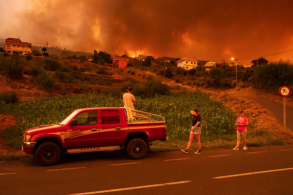 Residents try to reach their houses in Benijos village as a wildfire advances in La Orotava in Tenerife, Canary Islands, Spain, Aug. 19, 2023.(AP)