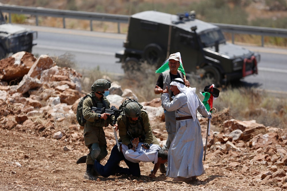 Israeli occupation forces detain a Palestinian man during a protest against the expansion of Israeli settlements in the village of Khirbet Jubarah near the West Bank city of Tulkarm, Thursday, Aug. 20, 2020. (AP)
