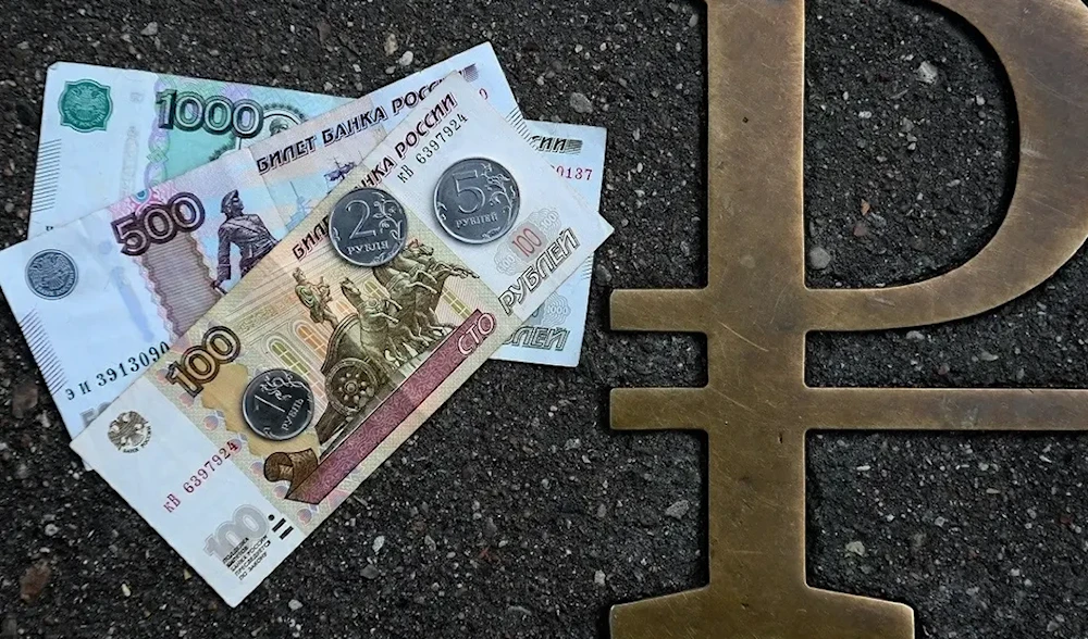 This picture taken on August 13, 2021, in Moscow, shows Russian ruble coins and banknotes pictured next to Russian ruble sign. (AFP)