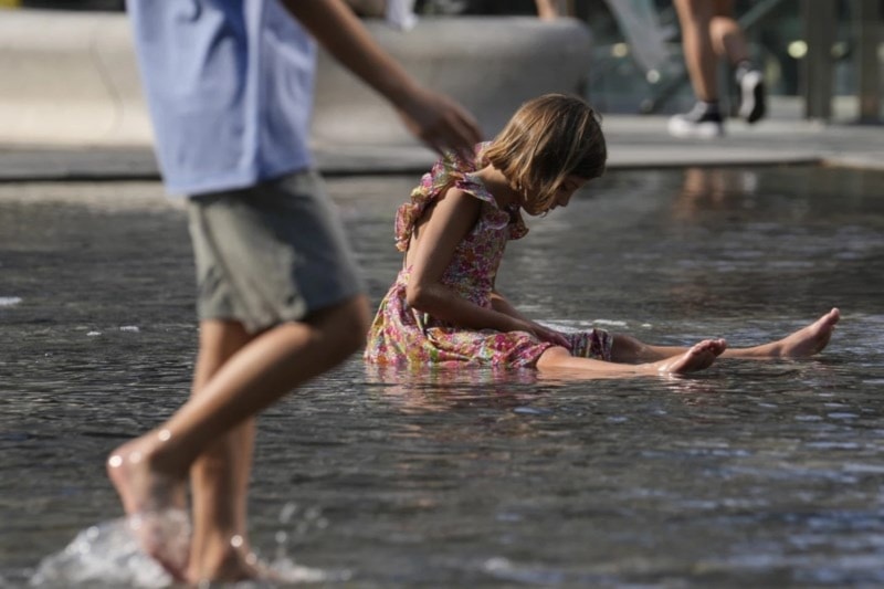 Children cool off in a public fountain in Milan, Italy on July 15, 2023. (AP)