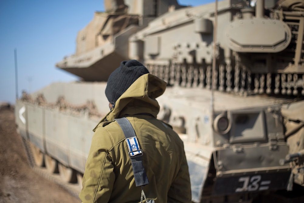 An Israeli occupation forces troop stands by a tank in the occupied Syrian Golan, Monday, Nov. 28, 2016. (AP)