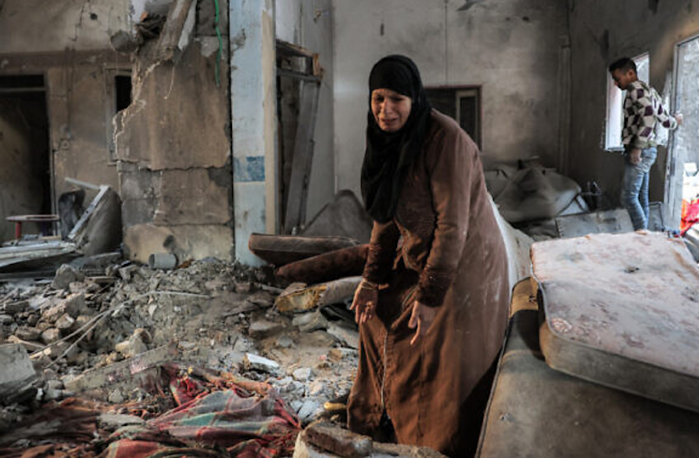 A Palestinian woman cries as she inspects a heavily damaged apartment following Israeli bombardment on Rafah in the southern Gaza Strip on February 8, 2024