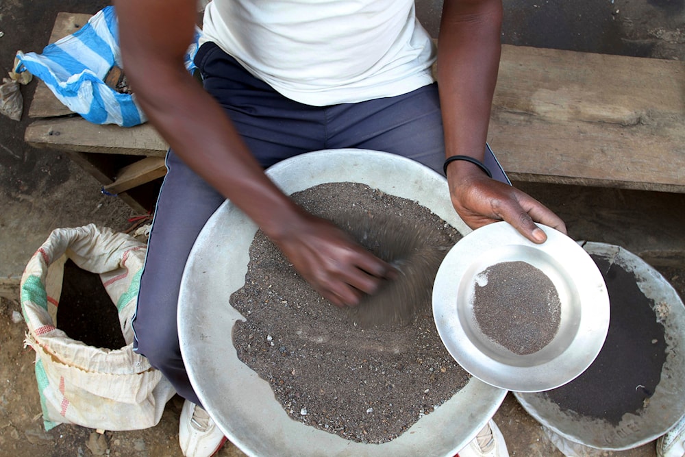 A Congolese miner sifts through ground rocks to separate out the cassiterite, the main ore that's processed into tin, in the town of Nyabibwe, eastern Congo, Aug. 16, 2012 (AP)