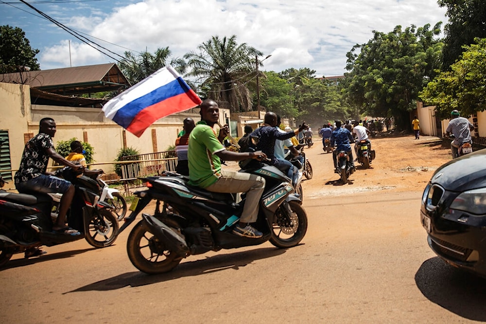 Supporters of Capt. Ibrahim Traore parade wave a Russian flag in the streets of Ouagadougou, Burkina Faso, Oct. 2, 2022 (AP)