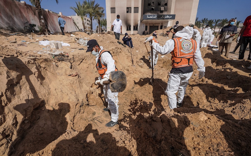Palestinian health workers dig for bodies buried at Nasser Hospital compound in Khan Younis in the southern Gaza Strip on April 21, 2024 (AFP)