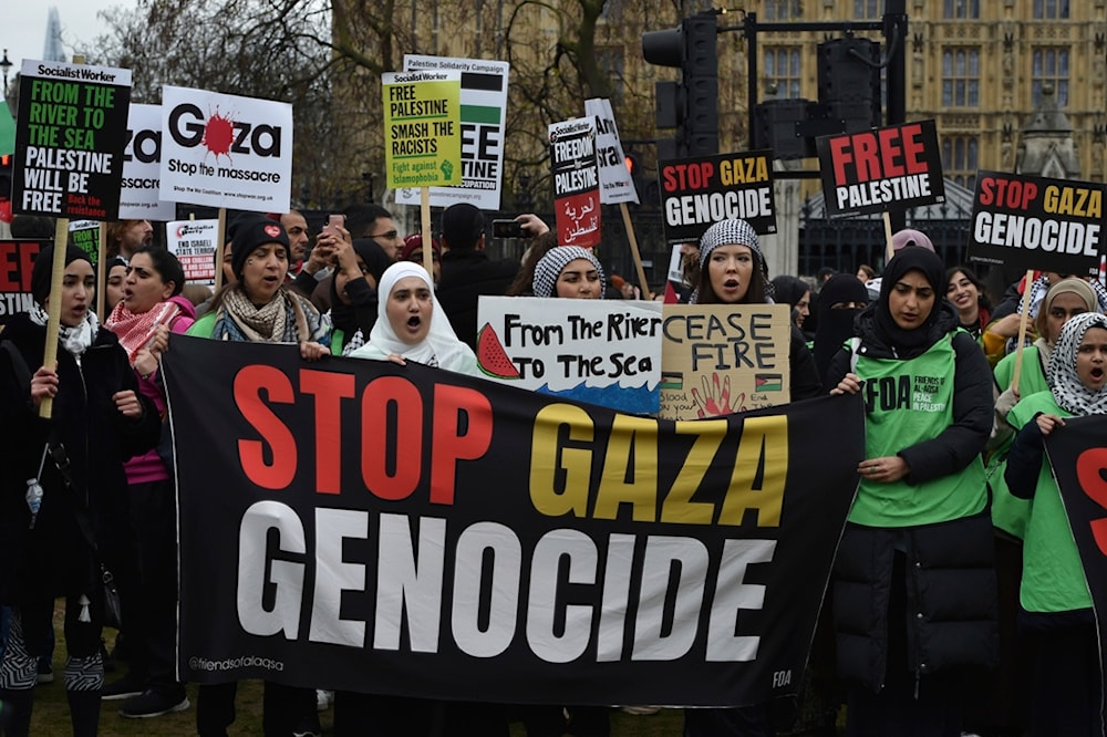 Pro-Palestine protesters hold banners and placards ahead of a march in support of the Palestinian people in Gaza, in London, Saturday, April 27, 2024 (AP Photo/Thomas Krych)