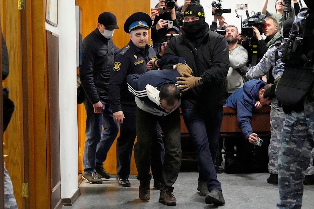 Saidakrami Murodali Rachabalizoda, a suspect in the Crocus City Hall shootings, is escorted by police and FSB officers in Basmanny District Court in Moscow, Russia, on March 24, 2024. (AP)
