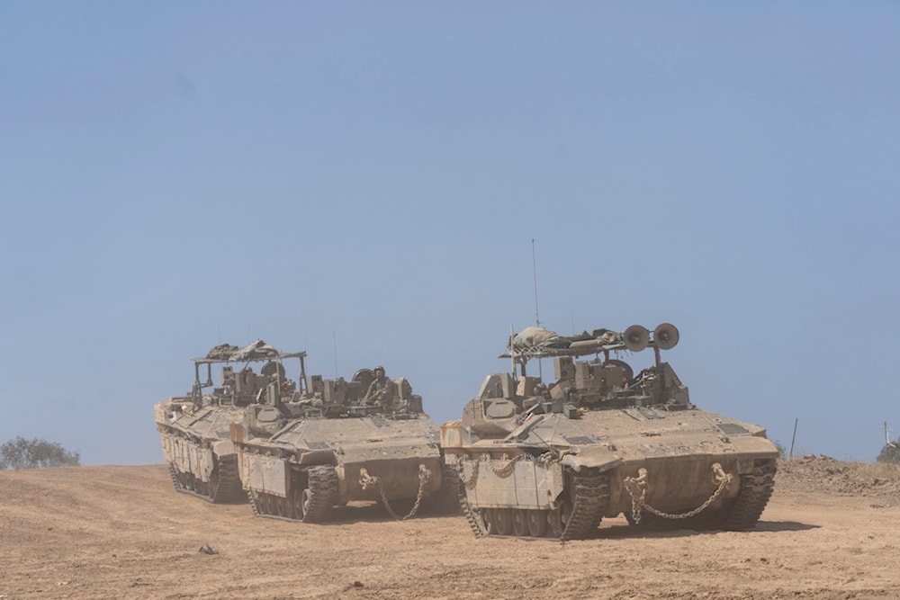 Israeli soldiers drive personnel carriers (APC) near the separation line with Gaza Strip, in southern Palestine, Monday, April 15, 2024. (AP Photo/Ohad Zwigenberg)