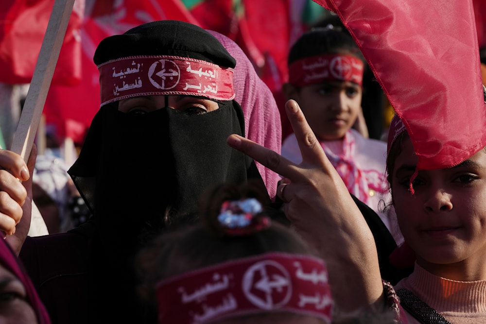 A woman from the Popular Front for the Liberation of Palestine (PFLP) waves her national and party's red flags in Gaza City, Thursday, Dec. 8, 2022. (AP)