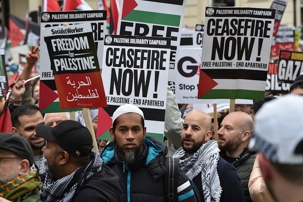 Pro-Palestinian protesters hold placards as they take part in a demonstration in London, Saturday, April 27, 2024. (AP)