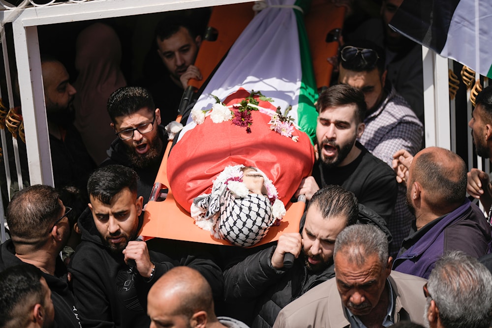 Palestinians carry the body of Omar Hamed during his funeral at the village of Beitin, near the West Bank city of Ramallah in the occupied West Bank, Sunday, April 14, 2024 (AP)