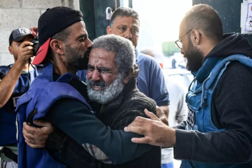Palestinian cameraman Mohammed Alaloul (L) hugs his father after two of his children and his brother were killed in an Israeli strike on the Al-Maghazi refugee camp. (AFP via Getty Images)