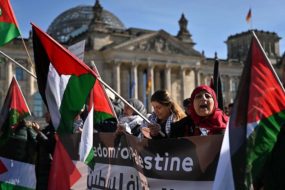 People with Palestinian flags protest in front of the Reichstag at a demonstration during a visit of Israeli Prime Minister Benjamin Netanyahu in Berlin, Germany, March 16, 2023 (AP)