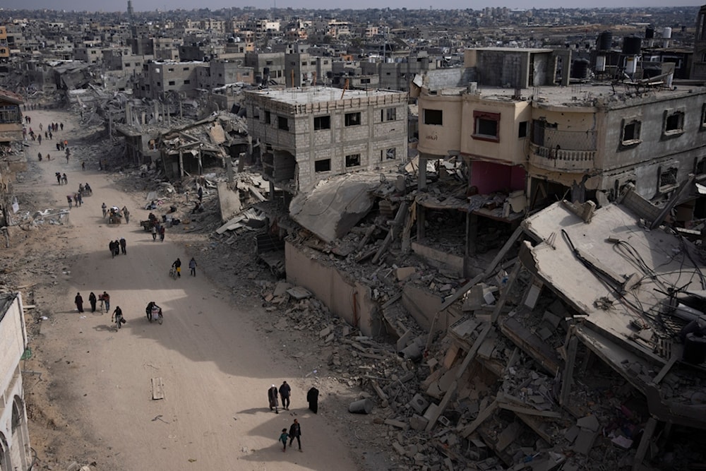 Palestinians walk through the destruction in the wake of an Israeli air and ground offensive in Khan Younis, southern Gaza Strip, Monday, April 8, 2024. (AP)