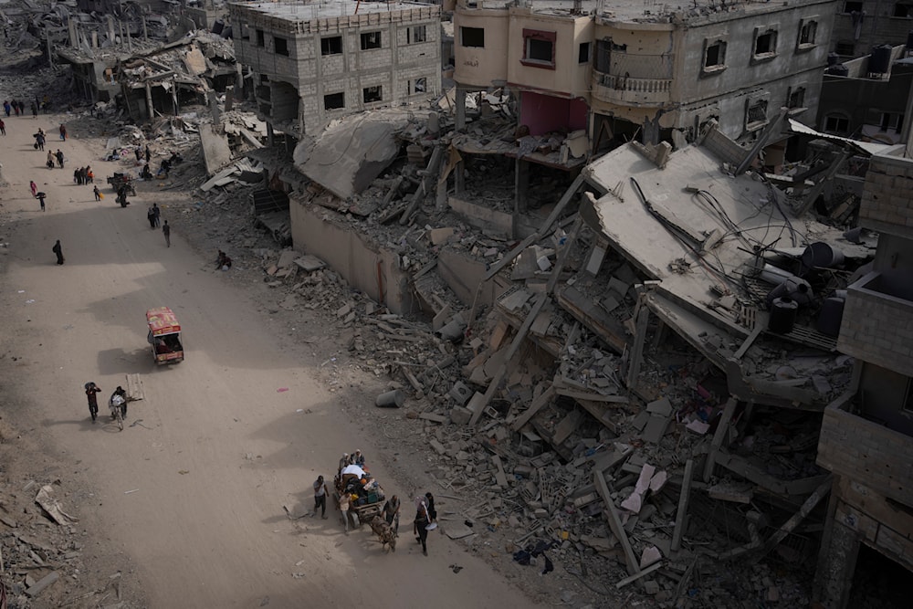 Palestinians walk through the destruction caused by an Israeli air and ground offensive in Khan Younis, southern Gaza Strip, Monday, April 8, 2024.(AP)