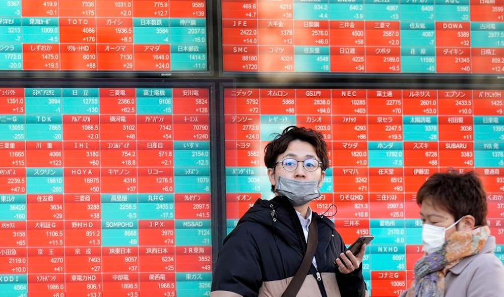 People stand in front of an electronic stock board showing Japan's stock prices at a securities firm Monday, Feb. 26, 2024, in Tokyo (AP)