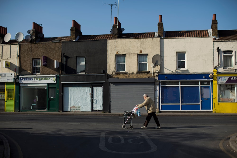 Britain High Street Lows** An elderly lady walks with a wheelie shopping bag past four closed shops on Trafalgar Road in Greenwich, London, Tuesday, March 5, 2013. (AP)