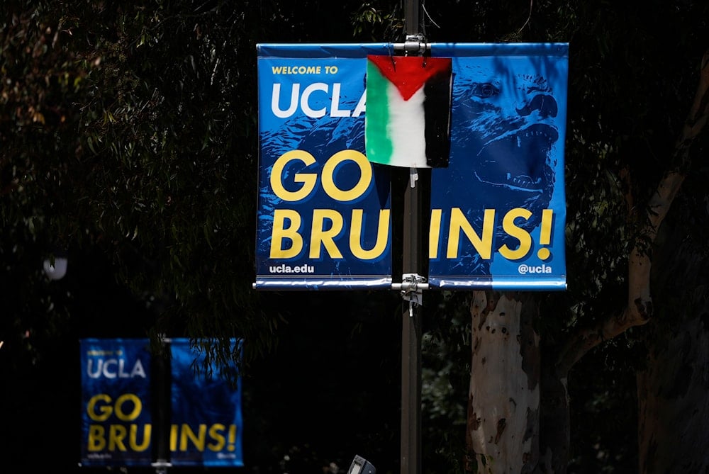 A Palestinian flag is placed over a university banner near an encampment to protest the Israel-Hamas war on the UCLA campus Tuesday, April 30, 2024, in Los Angeles. (AP)