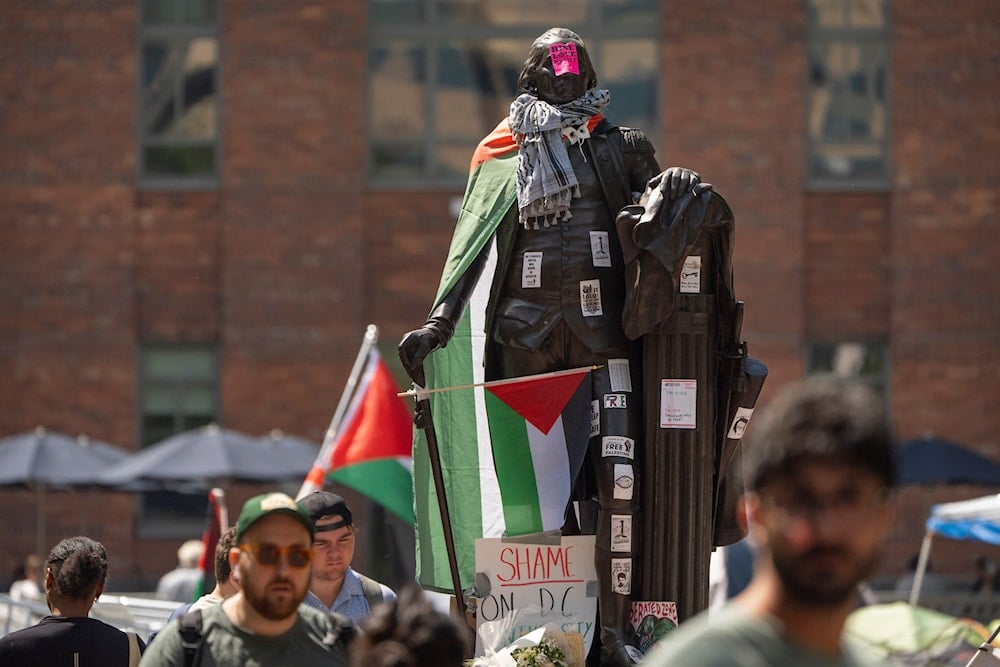 Stickers and Palestininan flags cover a statue of George Washington at an encampment by students at George Washington University on Tuesday, April 30, 2024, in Washington. (AP)