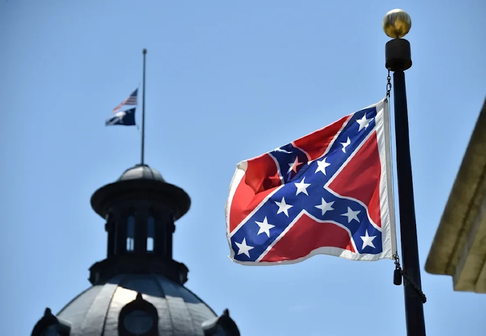 The South Carolina and American flags fly at half-staff behind the Confederate flag, in front of the State House in Columbia, South Carolina on June 19, 2015. (AFP)