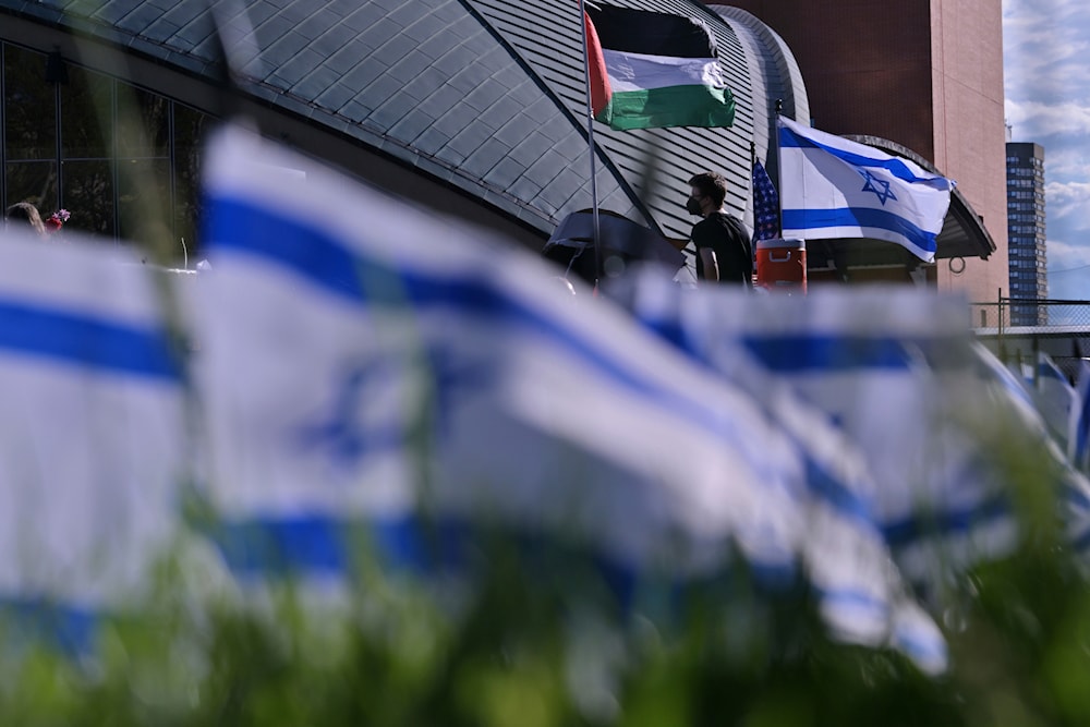 A man walks below flags flyng at a Pro-Palestinian encampment at MIT, Thursday, May 9, 2024, in Cambridge, Mass.(AP)