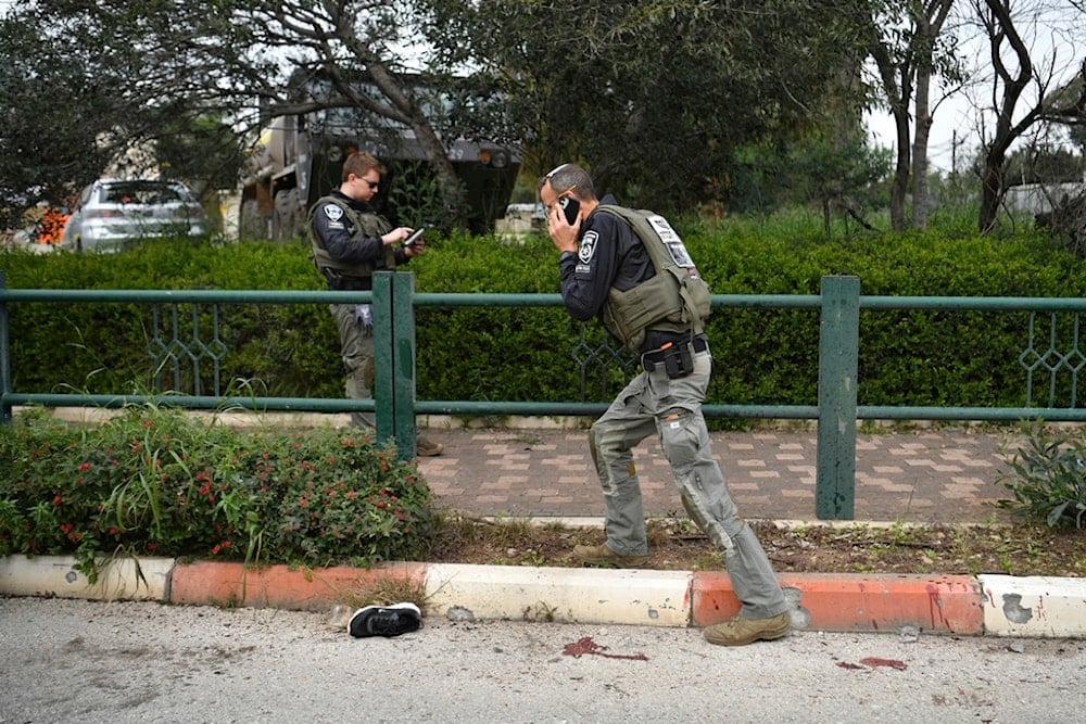 Israeli occupation forces examine the site hit by a rocket fired from Lebanon, in Kiryat Shmona, northern occupied Palestine, Tuesday, Feb. 13, 2024 (AP)