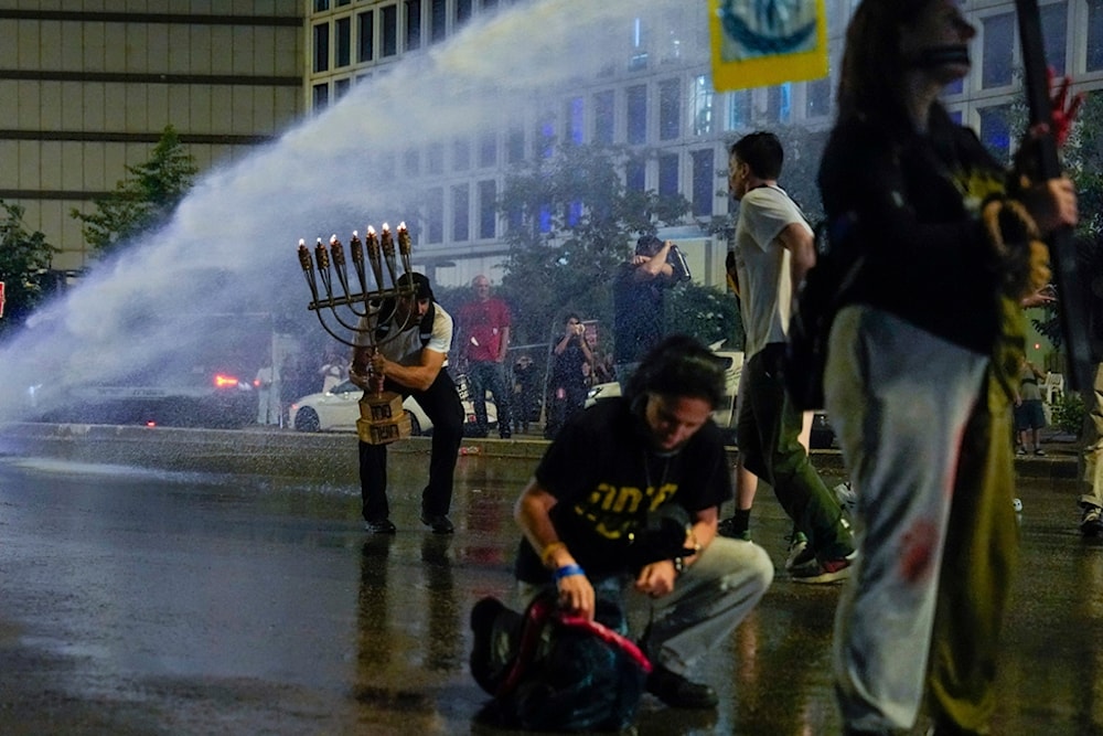 Israeli forces use water cannon to disperse demonstrators during a protest against Israeli Prime Minister Benjamin Netanyahu's government, and calling for the release of captives, Saturday, May 11, 2024. (AP)