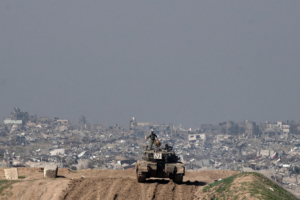 Israeli occupation forces overlook the Gaza Strip from a tank, as seen from southern occupied Palestine, Friday, Jan. 19, 2024. (AP)