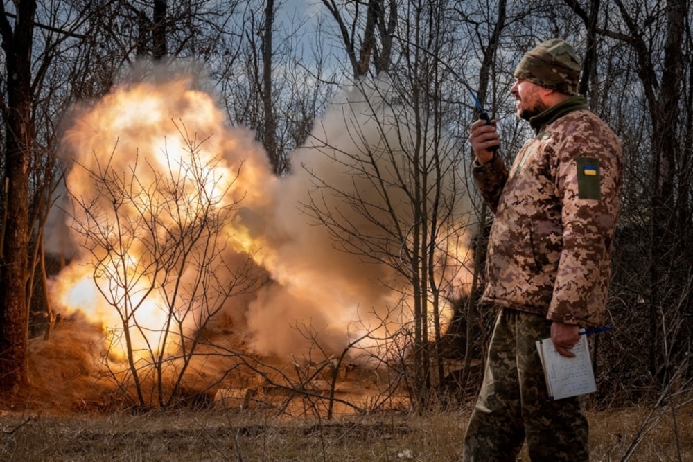 A Ukrainian officer observes the firing of a 152-mm Howitzer 2S3, towards Russian positions at the frontline, near Bakhmut, Donestk region, Ukraine, March 25, 2024 (AP)