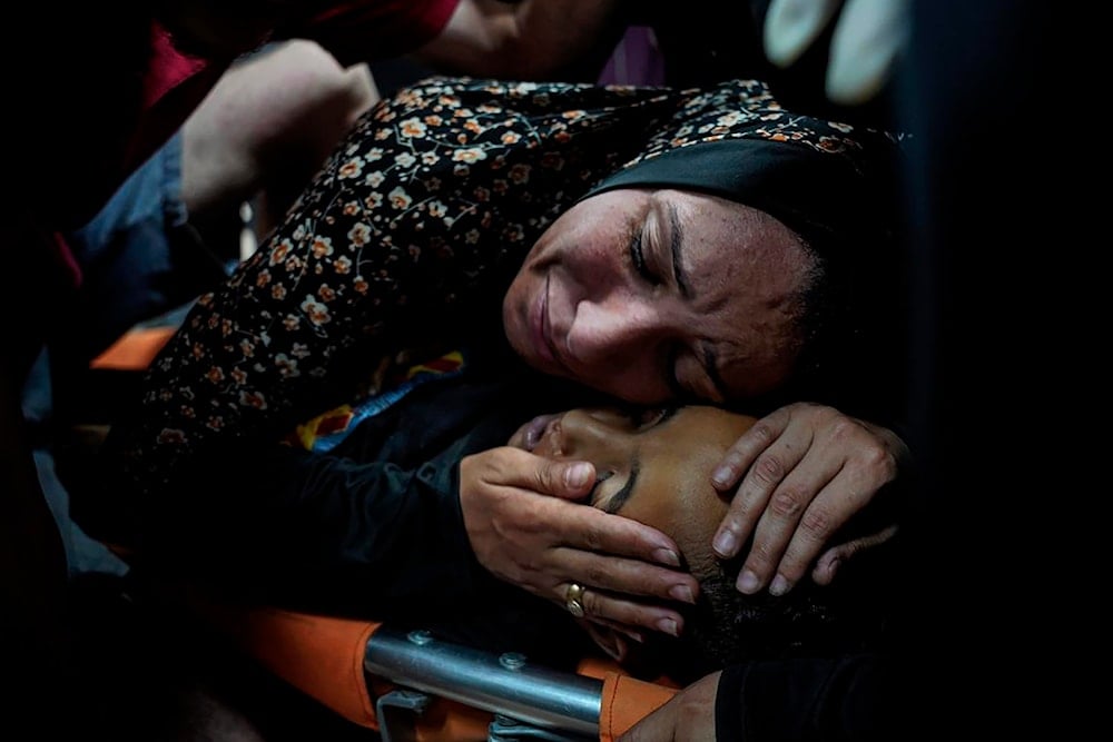 A Palestinian woman mourns her child, Mahmoud Essa, 12, who was killed in the Israeli bombardment of the Gaza Strip, at Al Aqsa Hospital in Deir al Balah, Gaza Strip, on May 12, 2024. (AP)