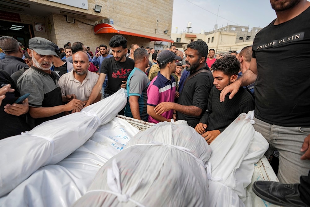 Palestinians load bodies of their relatives killed in the Israeli occupation bombardments of the Gaza Strip on a truck at Al Aqsa Hospital in Deir al Balah, Gaza Strip, Palestine, May 11, 2024. (AP)