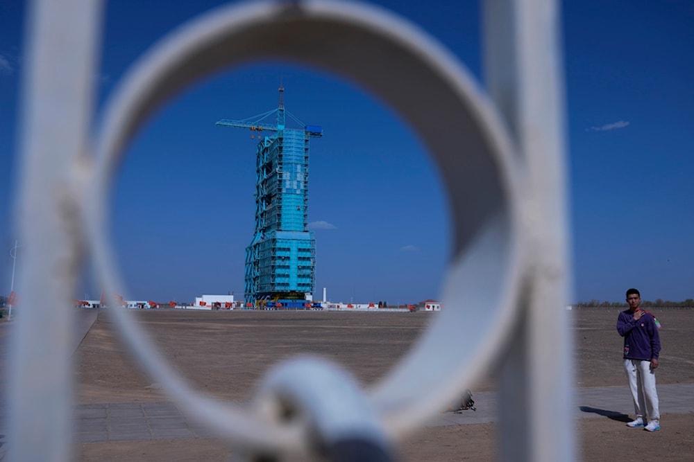 A soldier stands watch near the Shenzhou-18 spacecraft sitting atop a Long March rocket covered on a launch pad at the Jiuquan Satellite Launch Center in northwest China, Wednesday, April 24, 2024.